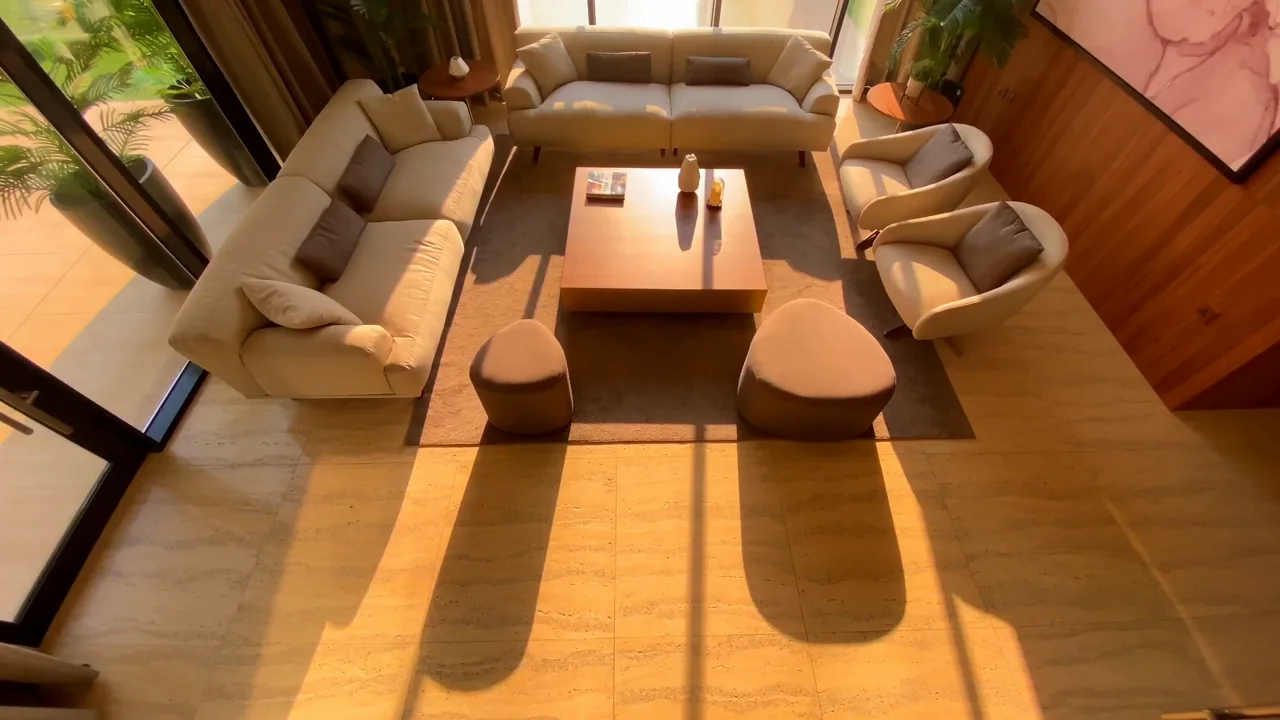 Sala com sofás claros, madeira e luz natural de fim de tarde